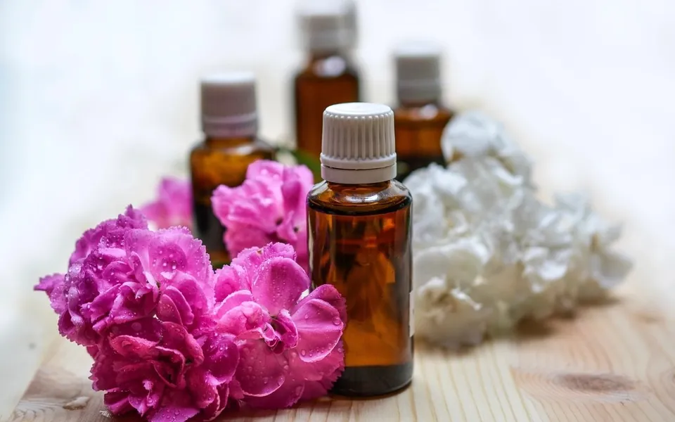 Amber essential oil bottles with pink and white flowers