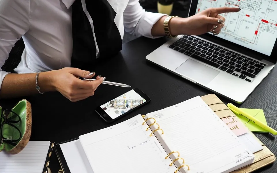 Planning a launch at a desk with a laptop and diary